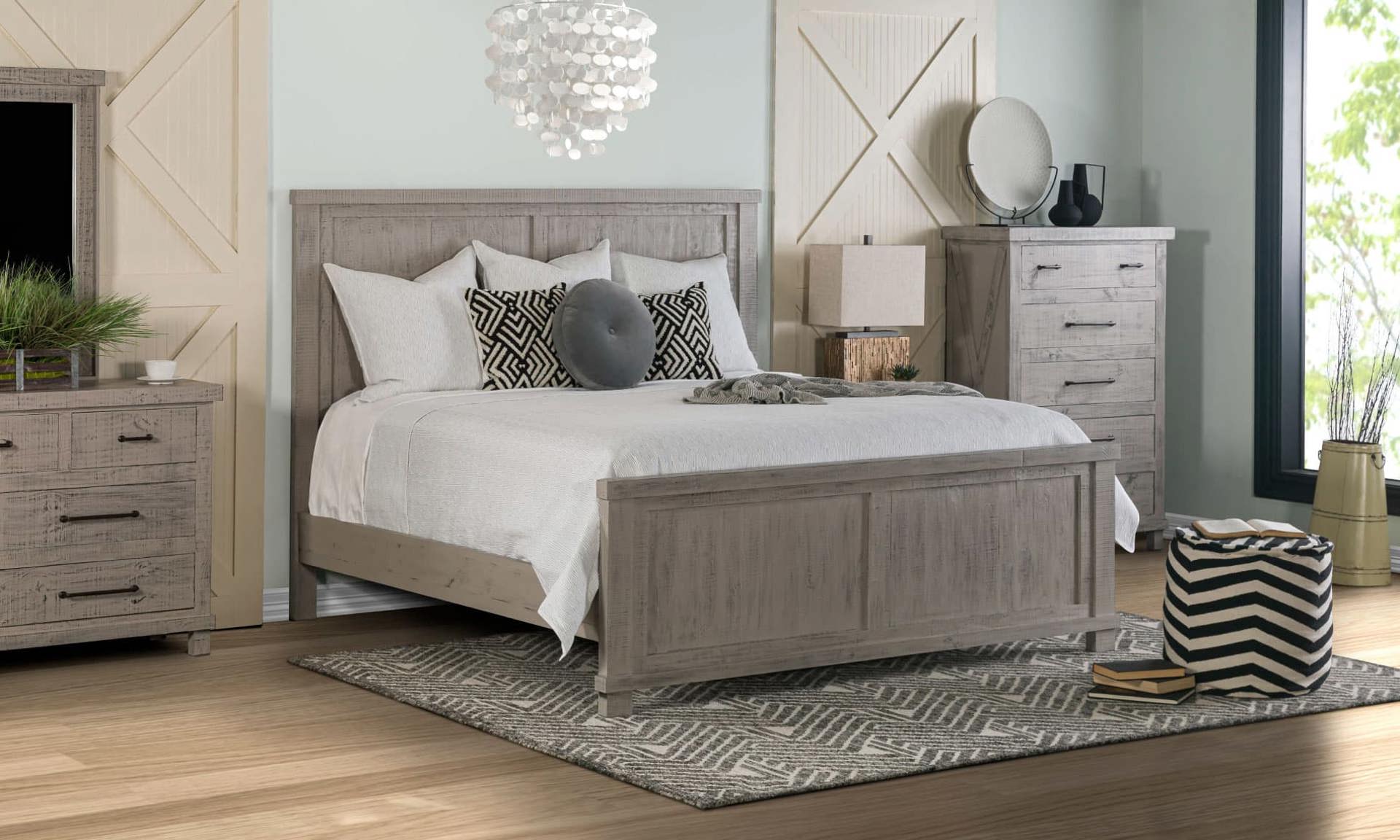 Beautiful neutral toned bedroom set featuring a bed, dresser and chest in a grey tone.