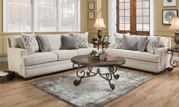 American-made couch and loveseat in a contemporary cream fabric with coordinating toss pillows.
