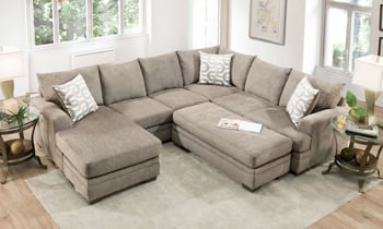 Sand-colored fabric upholstered chaise sectional with coordinating throw pillows.
