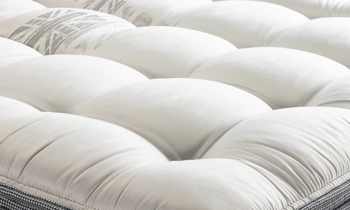 Hybrid plush mattress from the Britannica Royal Collection features memory foam and coils.