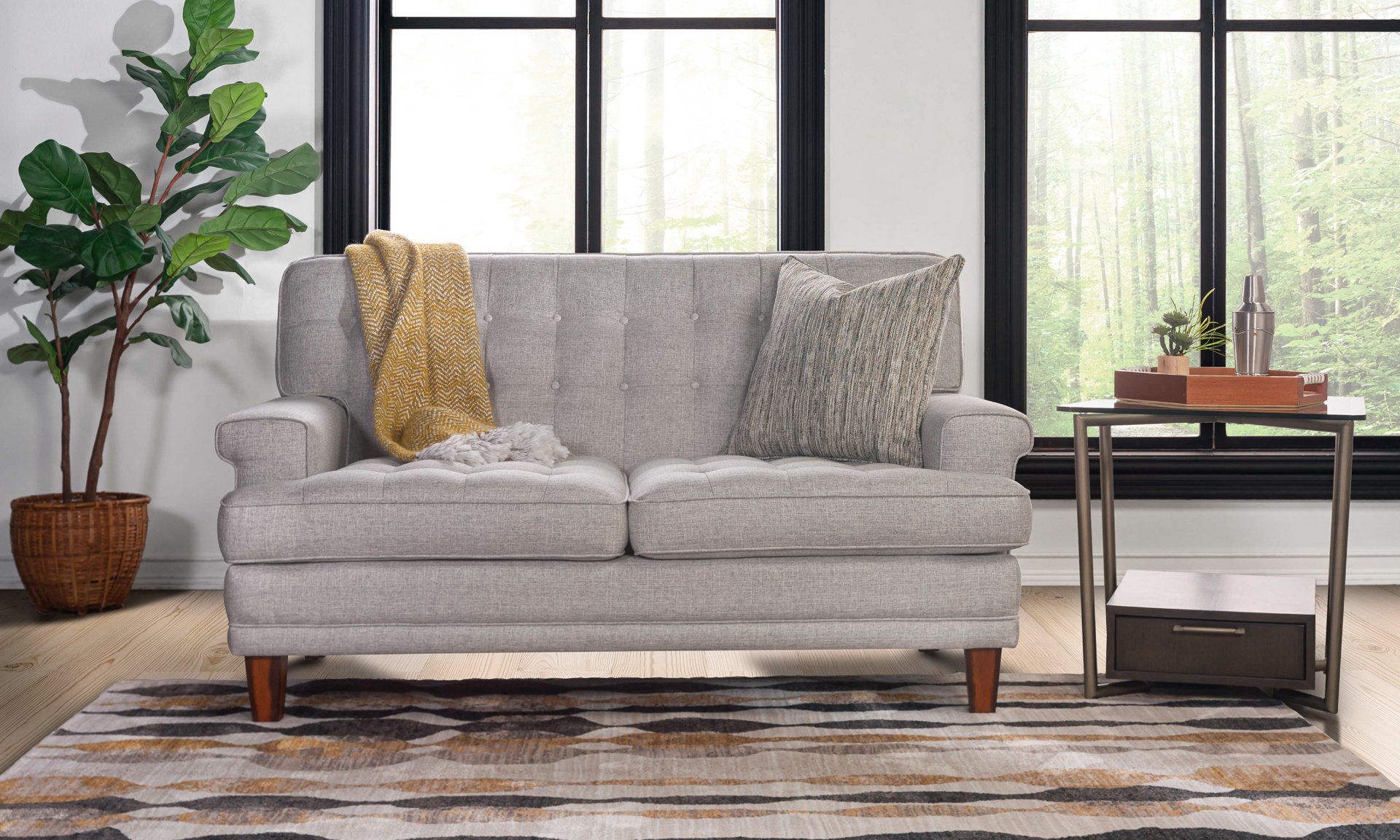 Grey tufted loveseat with key arms.